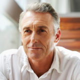 attractive older man sitting on stairs