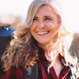 smiling older woman hiking on a hillside