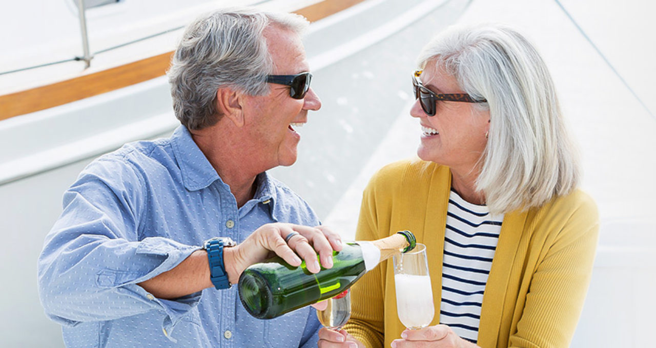 Mature couple enjoying a romantic date on a boat with champagne