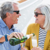 Mature couple enjoying a romantic date on a boat with champagne