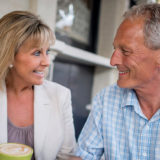 Smiling older couple outside with coffee