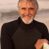 older man on beach surfing
