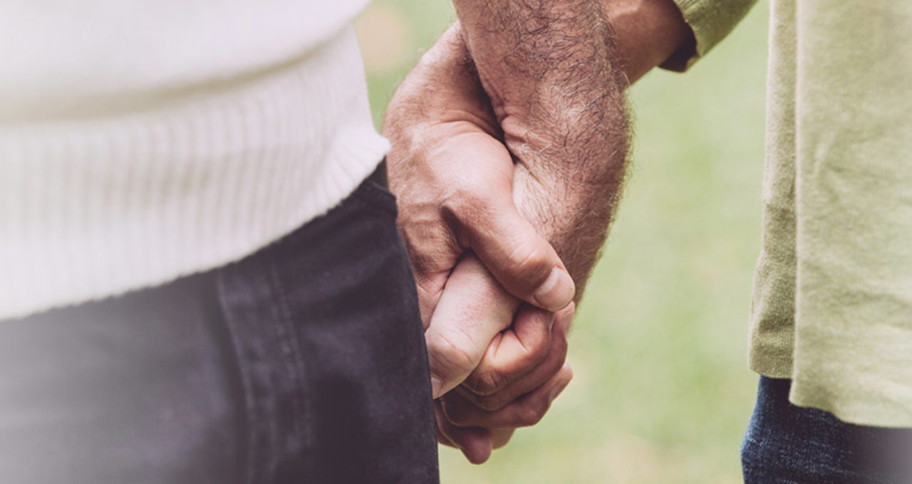 two older men holding hands