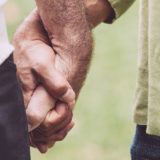 two older men holding hands
