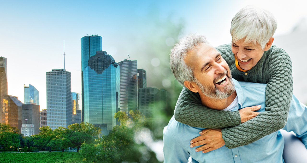 Image of a happy, smiling 50+ couple with a background of the city of the city of Houston.
