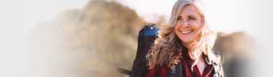 smiling older woman hiking on a hillside