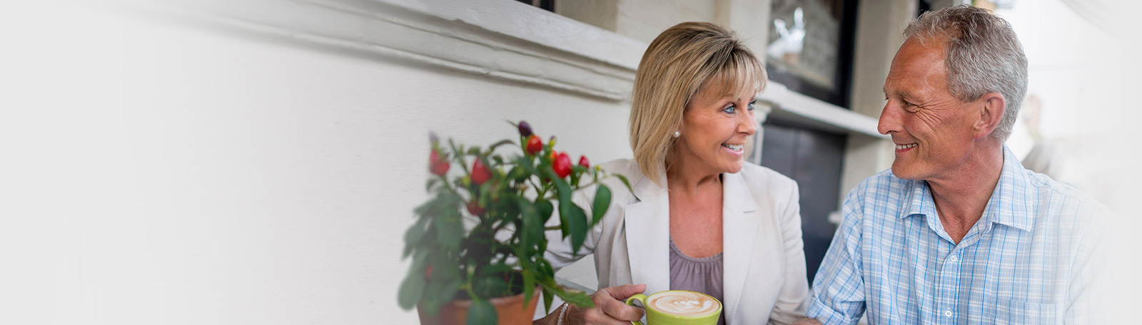 Smiling older couple outside with coffee